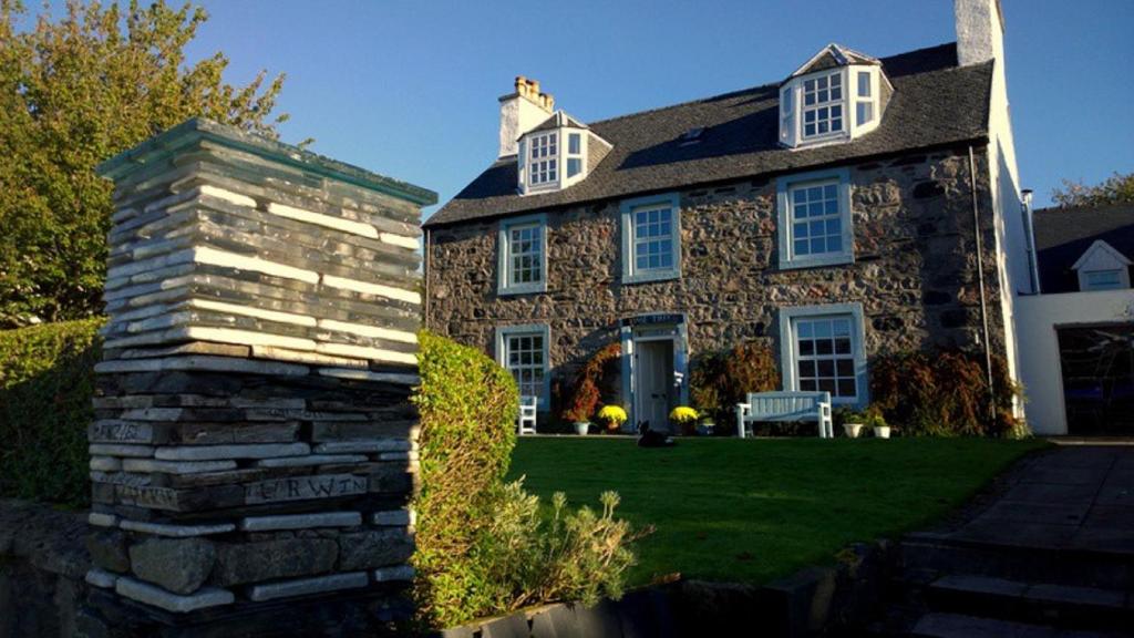 a stone house with a bench in front of it at Lime Tree Hotel in Fort William