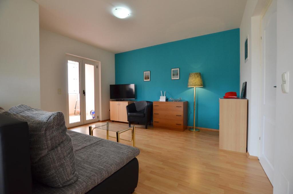 - un salon avec un canapé et un mur bleu dans l'établissement Apartment Kliska, à Rovinj