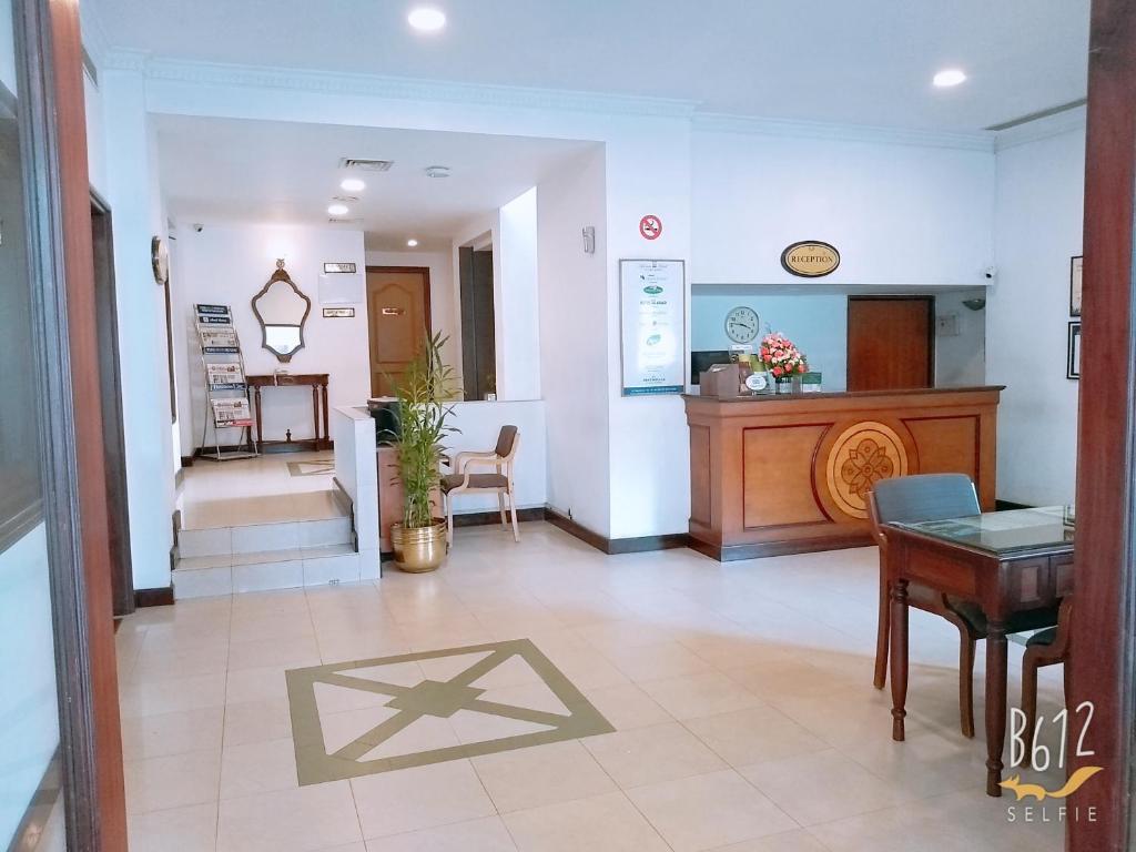 a lobby of a hospital with a table and chairs at Abad Metro in Cochin