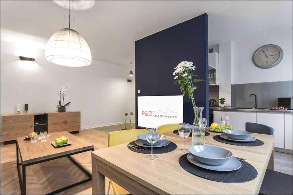 a kitchen and living room with a table and a dining room at P&O Serviced Apartments NOWOGRODZKA in Warsaw