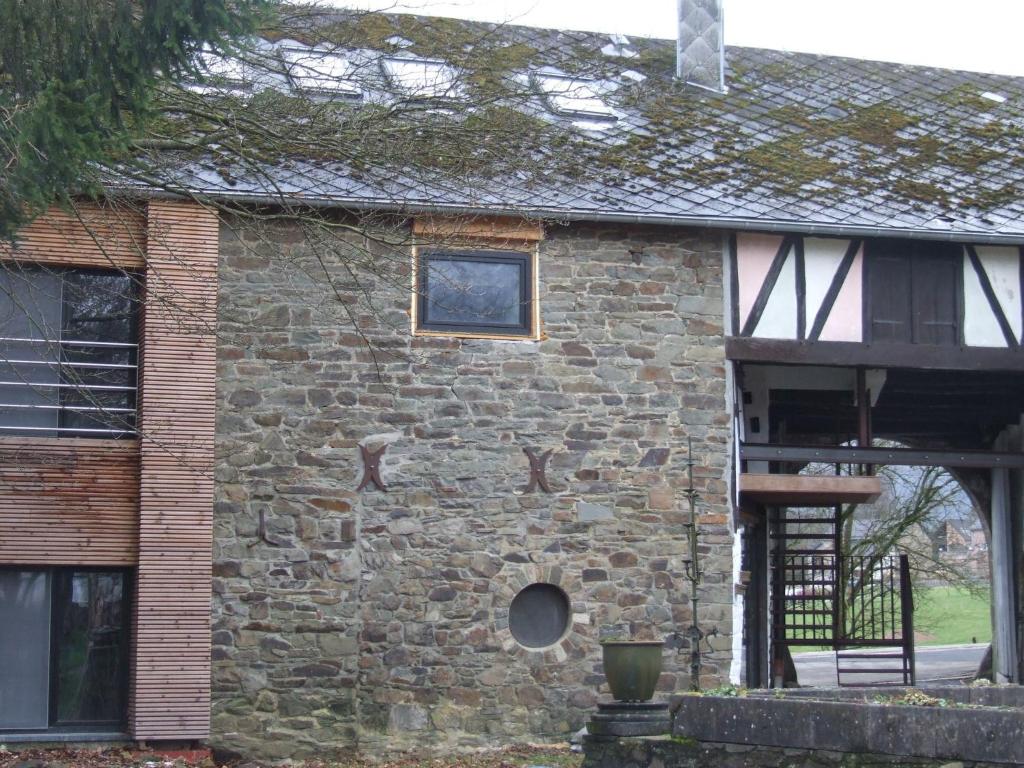 um antigo edifício de pedra com uma janela e uma escada em Luxurious Mansion in Robertville near Forest em Robertville