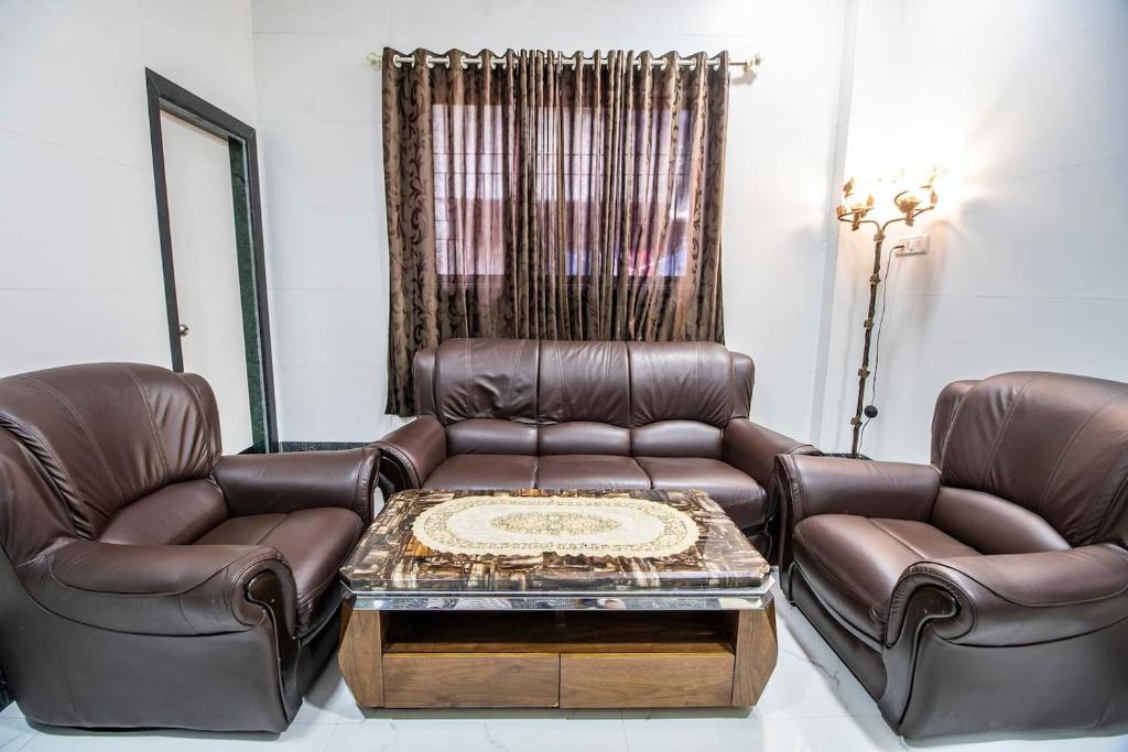 a living room with two leather chairs and a coffee table at OSI Apartments Sahar Andheri East in Mumbai
