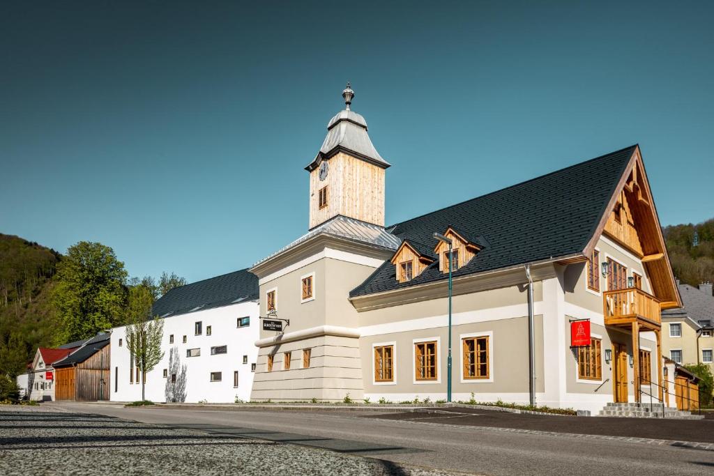 a white church with a tower on a street at Hotel zum Glockenturm in Marktl