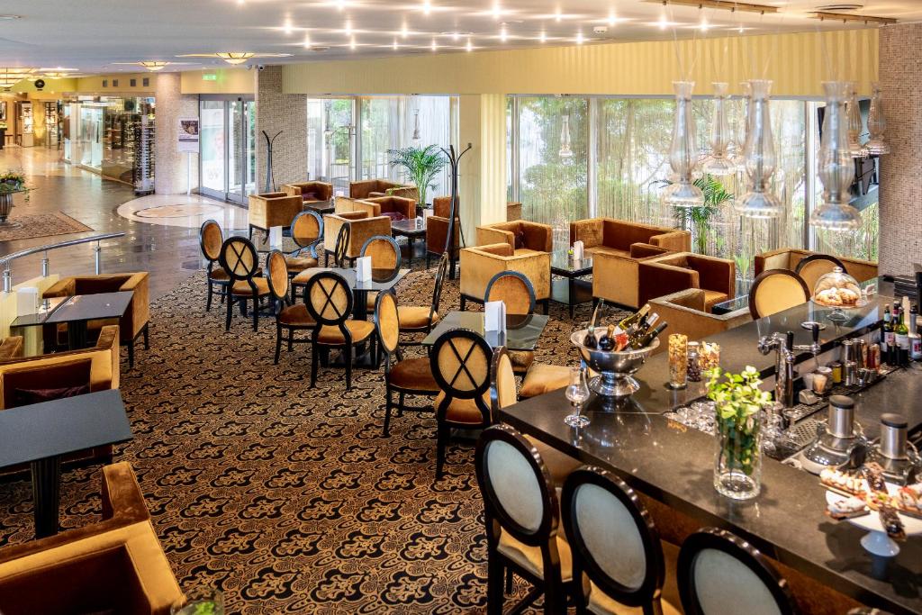 a restaurant with tables and chairs in a lobby at Baltic Beach Hotel & SPA in Jūrmala
