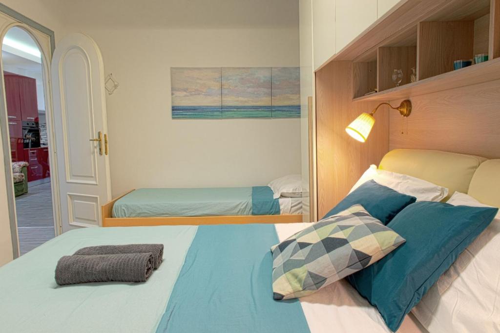 1 dormitorio con 1 cama grande con almohadas azules en La Maison In Rome, en Roma