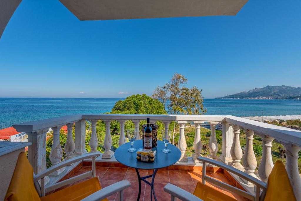 a balcony with a table and chairs and the ocean at Seafront Spirit Suites in Zakynthos