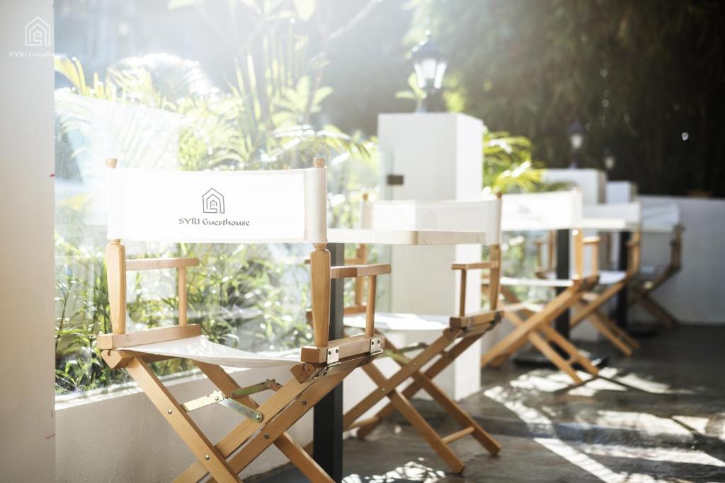 a row of chairs sitting in front of a window at SYRI Guesthouse Vientiane Hostel & Cafe in Vientiane