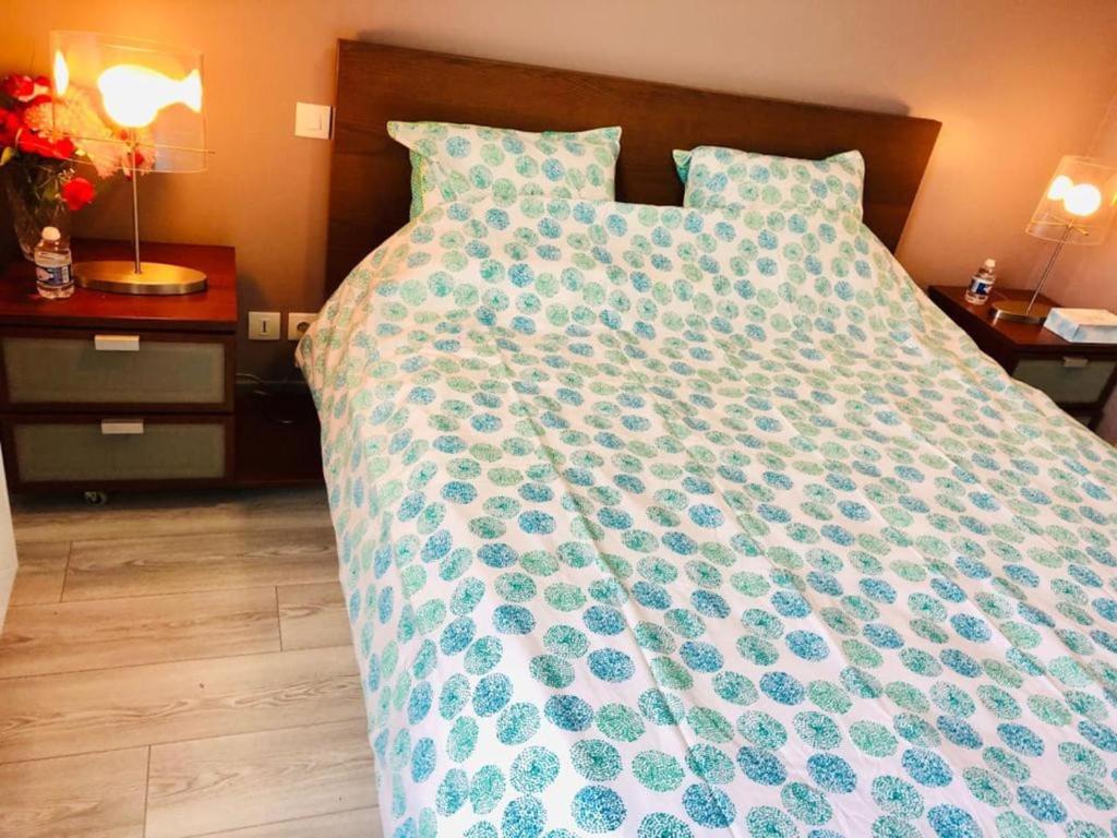 łóżko z niebiesko-białą kołdrą w obiekcie Near DISNEYLAND. Your location to enjoy holidays. w mieście Bussy-Saint-Georges