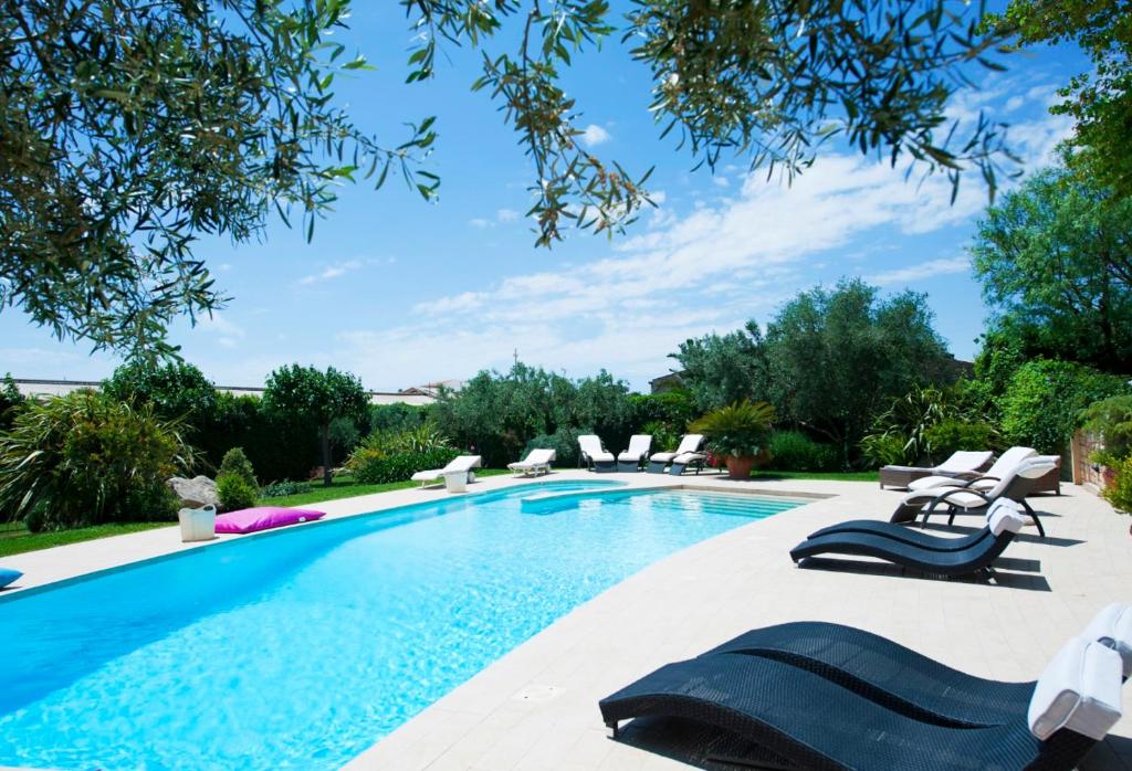 a swimming pool with chaise lounge chairs next to it at Stone House Modica in Modica