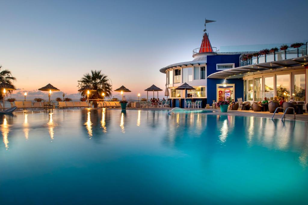 a large swimming pool in a resort at night at Hotel Villaggio Stromboli in Santa Domenica