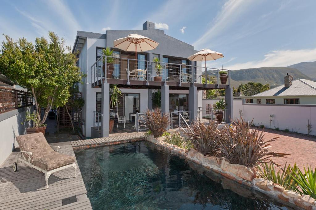 a house with a swimming pool in front of a house at Whale Away Guest House in Hermanus