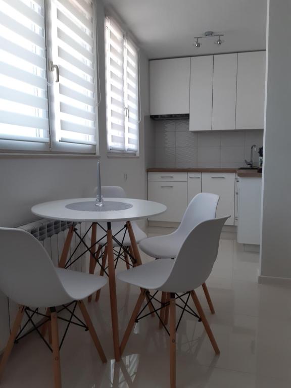 a white kitchen with a table and chairs at Sobieskiego in Skierniewice