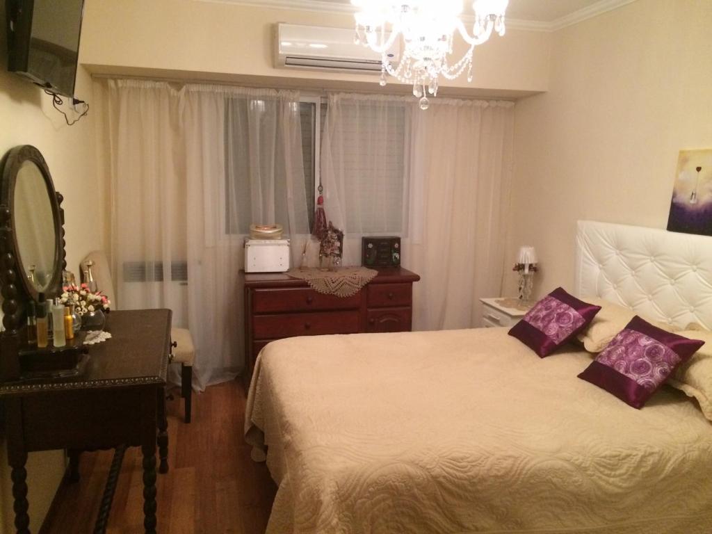 a bedroom with a bed and a dresser and a mirror at Confortable departamento entero in Belén de Escobar