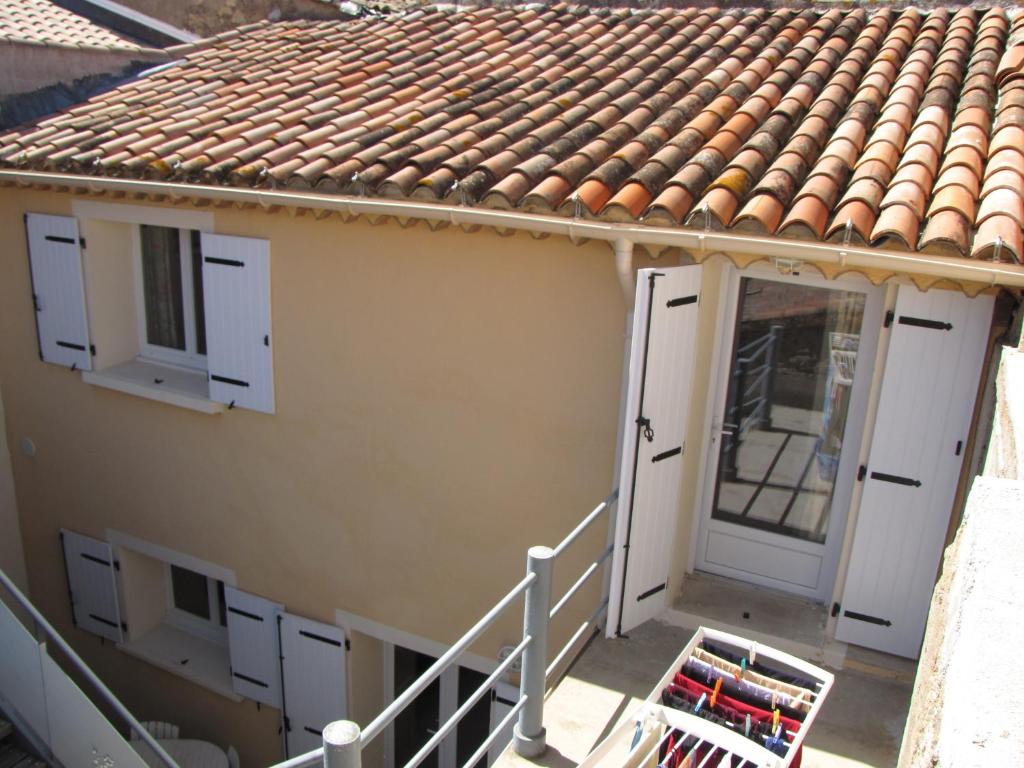 une maison avec des portes blanches et un toit carrelé dans l'établissement maison de village entre mer et montagne, à Roujan
