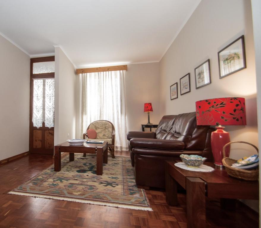 uma sala de estar com um sofá de couro e uma mesa em Casa da Avó - Vila do Porto em Vila do Porto