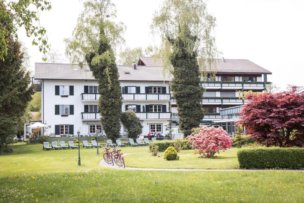 un gran edificio blanco con bicicletas estacionadas en un parque en Garden-Hotel Reinhart en Prien am Chiemsee