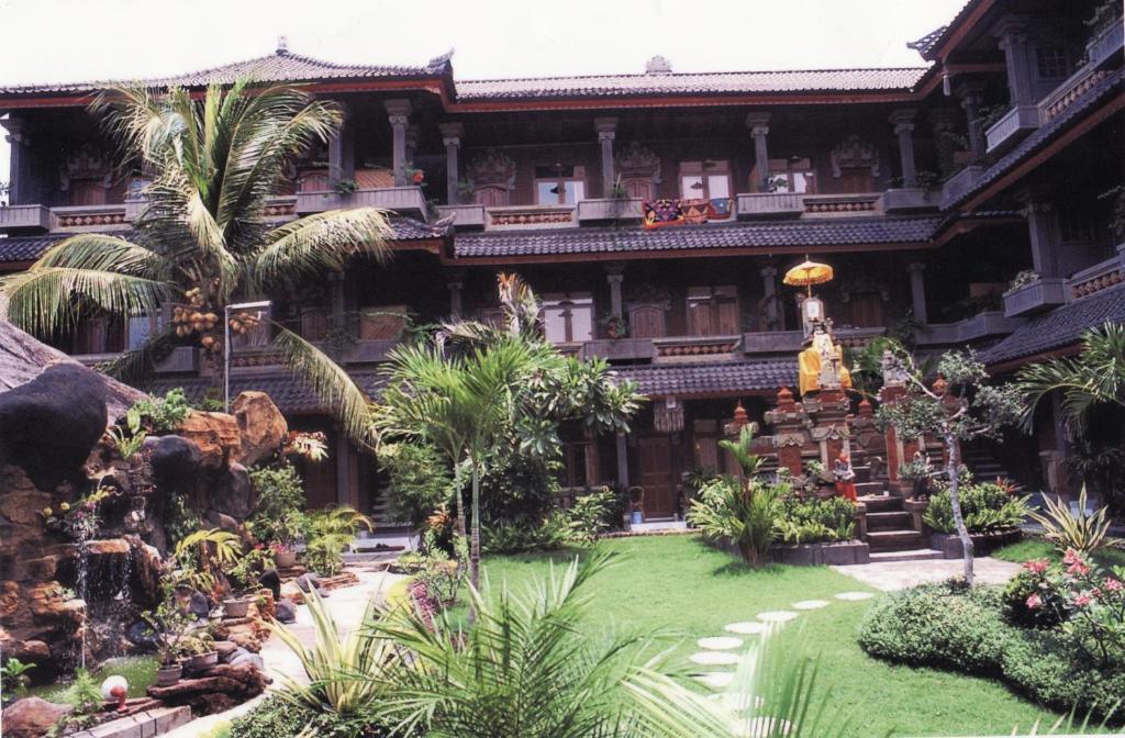 a building with a garden in front of it at Hotel Sorga Cottages in Kuta