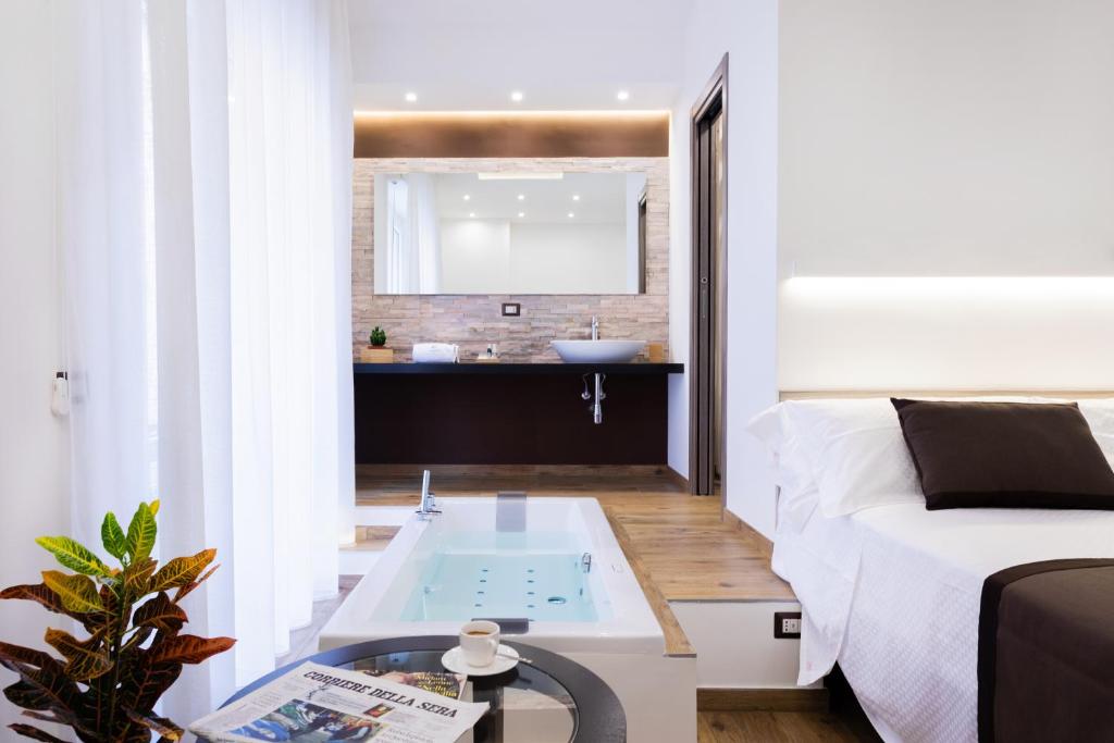 パレルモにあるLighea aqua suites and breakfastのベッド1台、バスルーム(バスタブ付)が備わります。