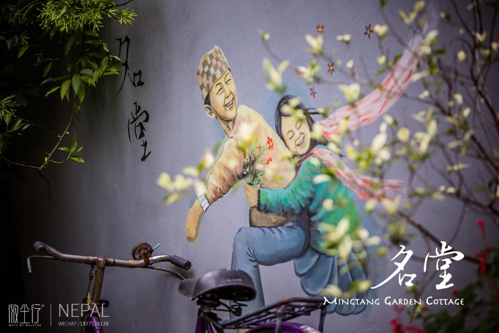 una pintura de dos personas en una pared en Mingtang Garden Cottage 名堂花园度假屋 en Pokhara