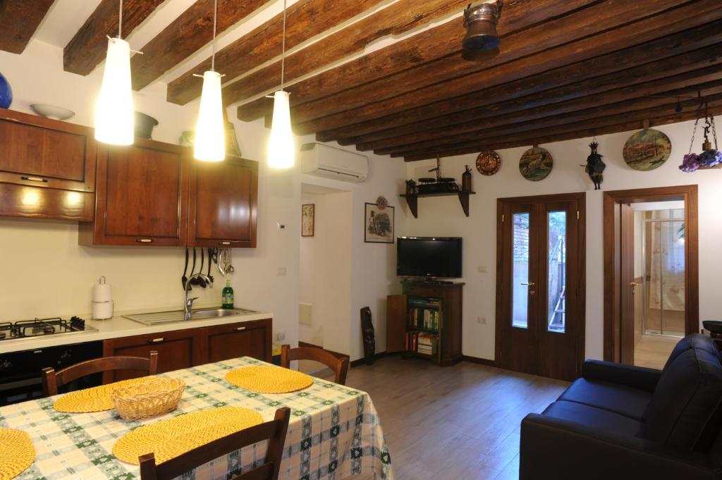 a kitchen and a dining room with a table and a kitchen and a room with at APPARTAMENTO PARADISO CA' GIULIA in Venice