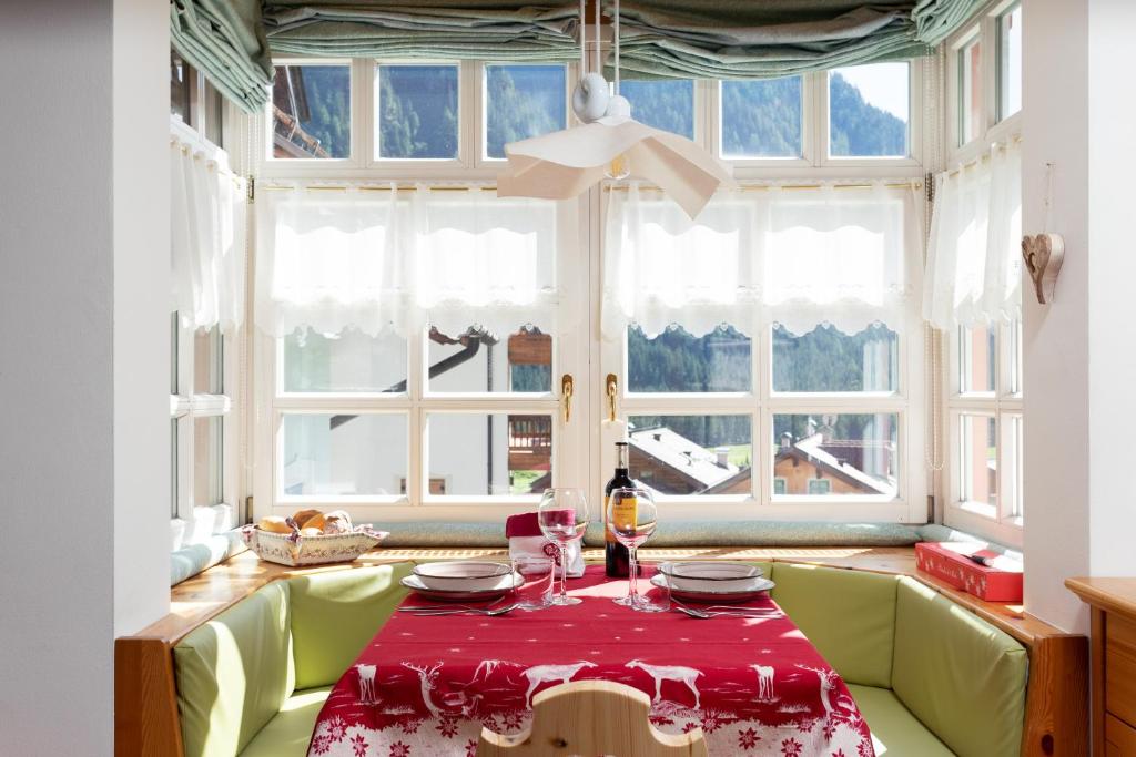 ein Esszimmer mit einem roten Tisch und einem Fenster in der Unterkunft Kristiania in Campitello
