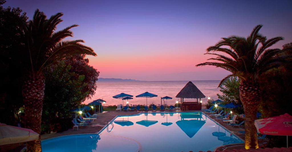a swimming pool with a view of the ocean at night at Camping Nopigia in Kissamos