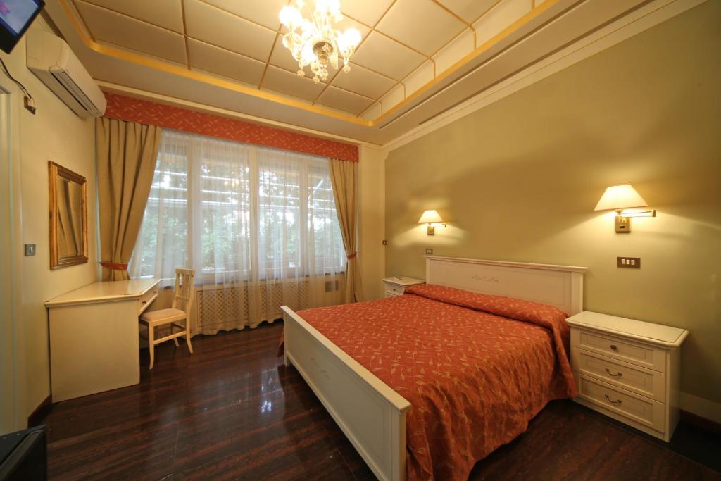 a bedroom with a bed and a desk and a window at B&B La Terrazza in Brescia