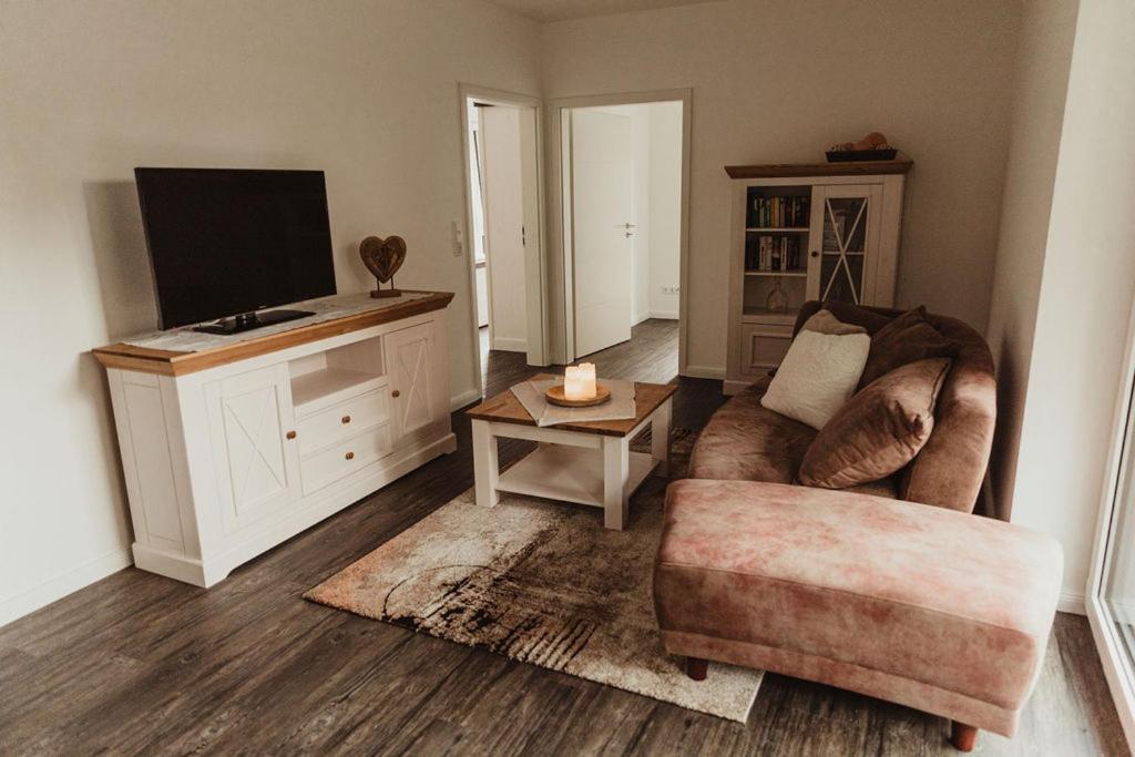 uma sala de estar com um sofá e uma televisão em Apartment Strandläufer em Aurich