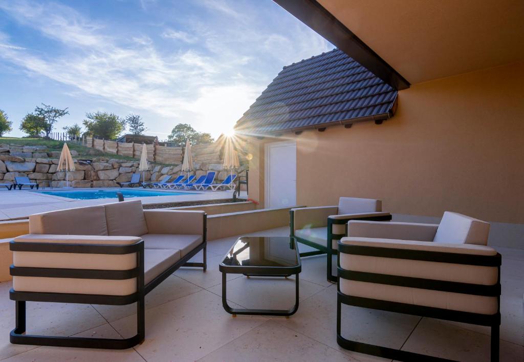 une terrasse avec des chaises, une table et une piscine dans l'établissement Hotel Keimberg, à Cleebourg