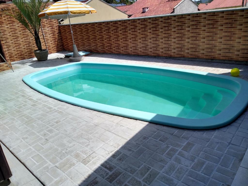 uma piscina com uma piscina turquesa em Casa com Piscina em Brusque