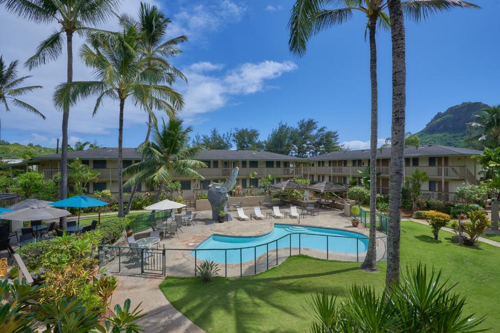 a view of the resort with a pool and palm trees at The Kauai Inn in Lihue