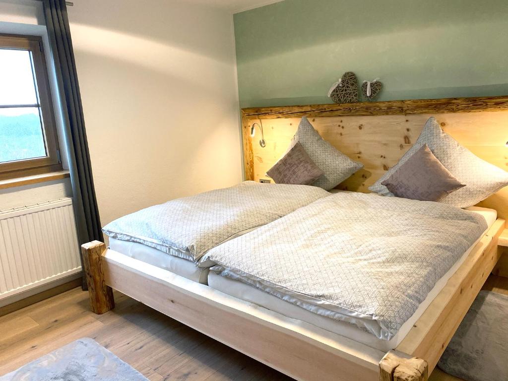 a bedroom with a bed with a wooden headboard at Allgäu-Feeling in Rettenberg