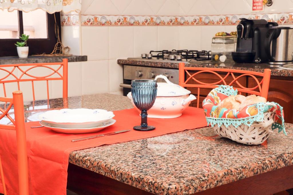 a kitchen with a counter top with a table with a red cloth at Casa Beta in Peniche