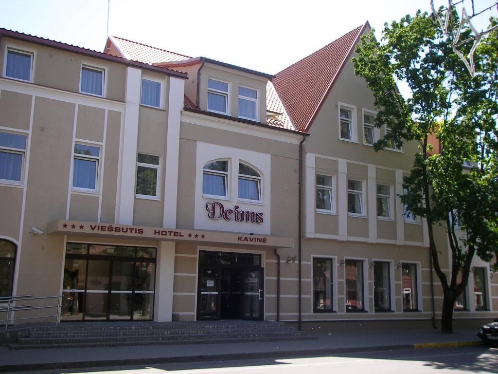 a building with a sign that reads detours at Deims Hotel in Šilutė
