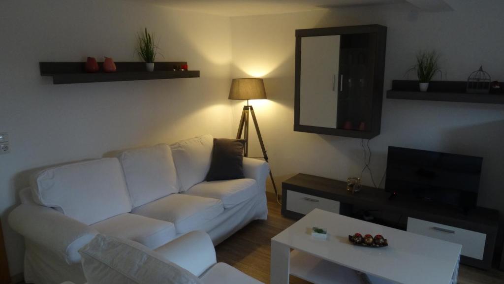 a living room with a white couch and a table at Ferienwohnung bei Erfurt in Gebesee