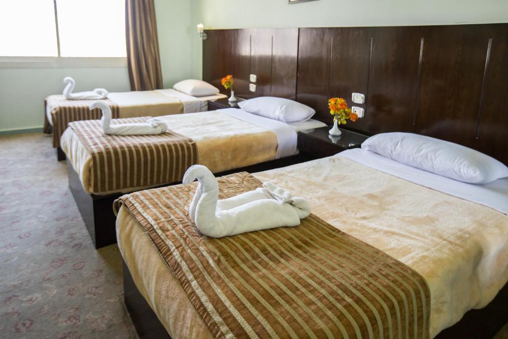 Postel nebo postele na pokoji v ubytování Aura Inn Hotel Cairo