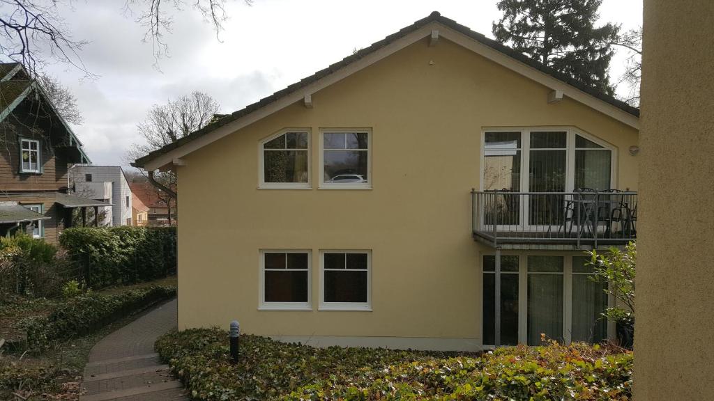 een geel huis met een balkon erboven bij FERUN in Zinnowitz