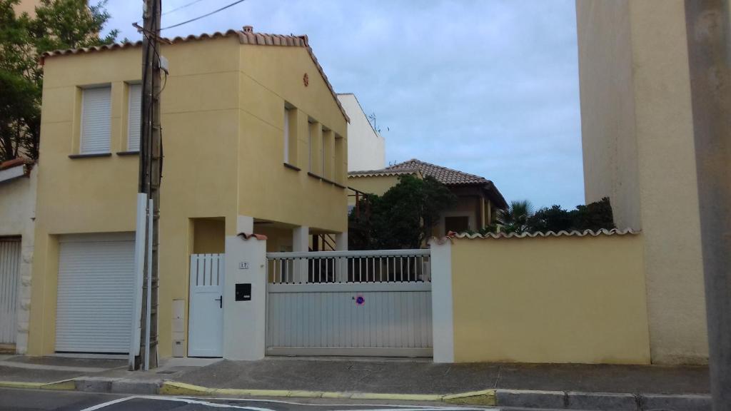 een huis met een witte poort en een hek bij Petite RAFALE in Valras-Plage