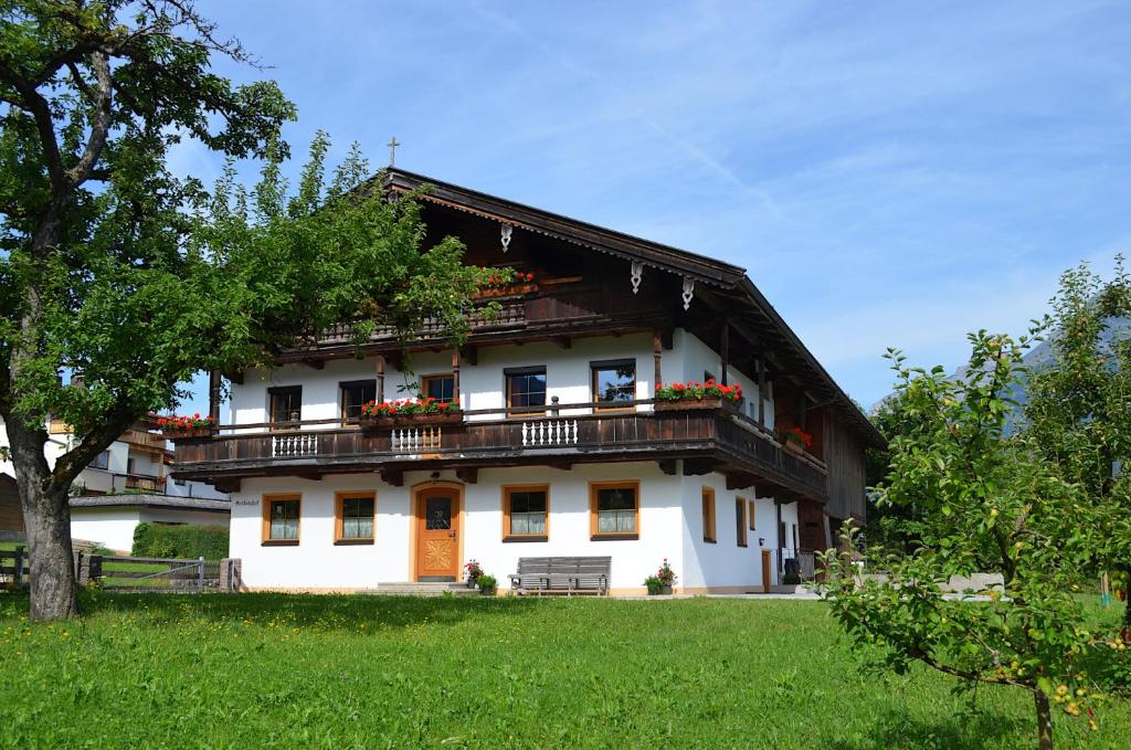 een groot wit huis met een balkon bij Kienberghof in Reith im Alpbachtal