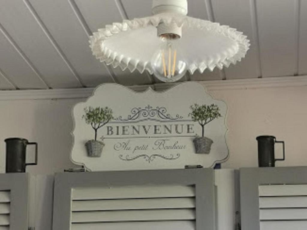 a light hanging from a ceiling with a sign on it at Guest House Provencal in Vitrolles