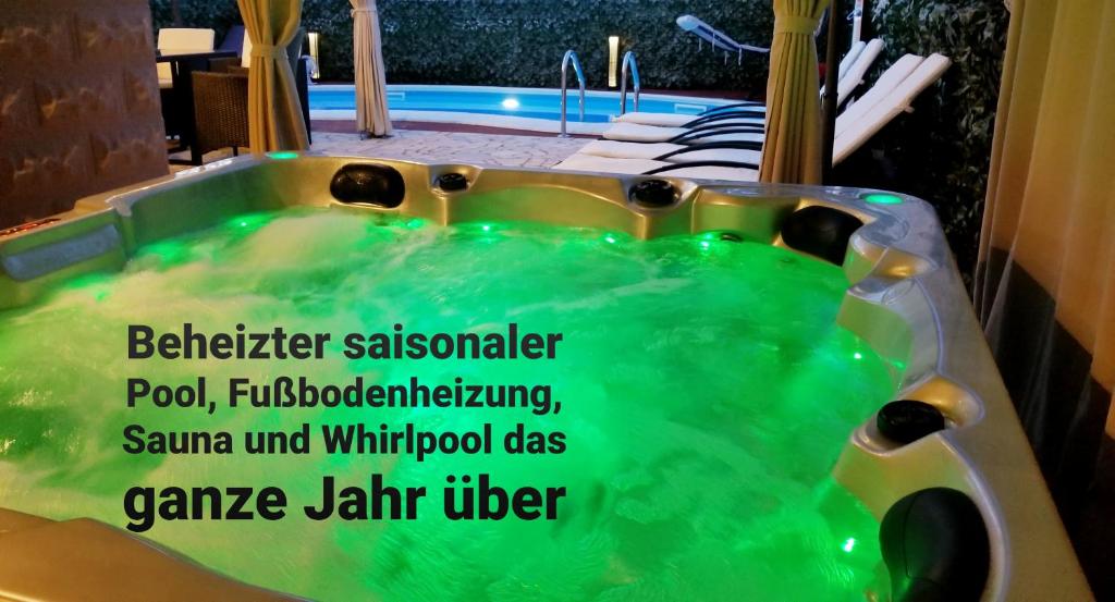 łazienka z wanną z zieloną wodą w obiekcie Villa Summer dream with heated pool, sauna and jacuzzi w mieście Malinska