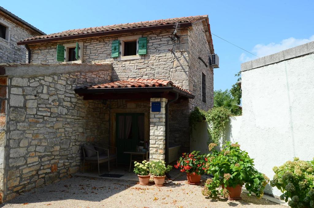 une maison en pierre avec des plantes devant elle dans l'établissement Apartment Duerose, à Buje