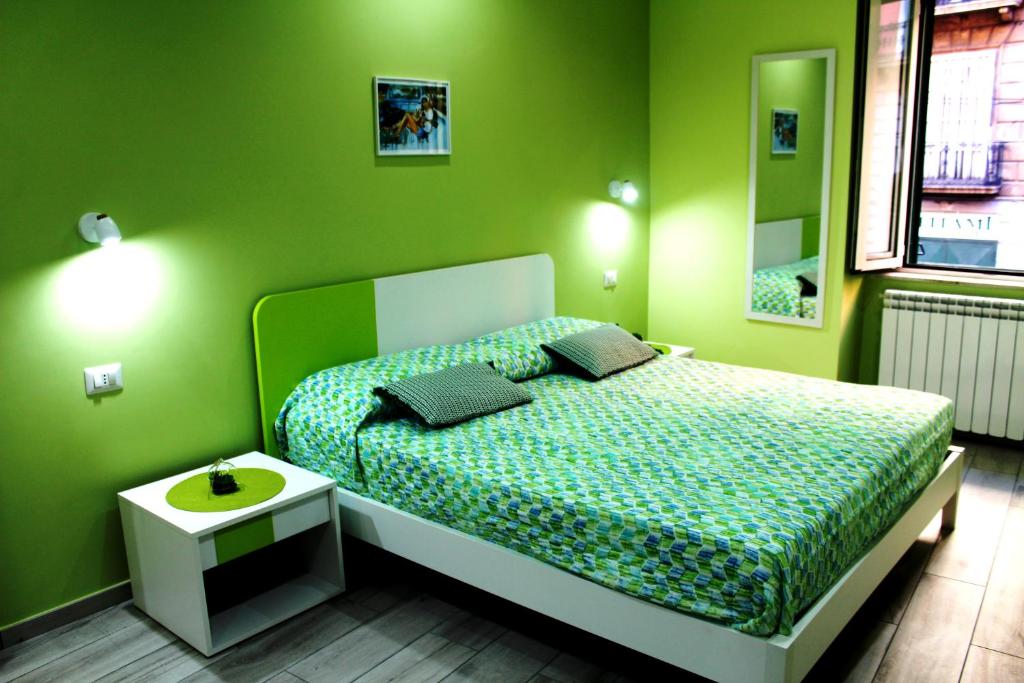 - une chambre dotée d'un lit avec un mur vert dans l'établissement Anima Migrante, à Naples