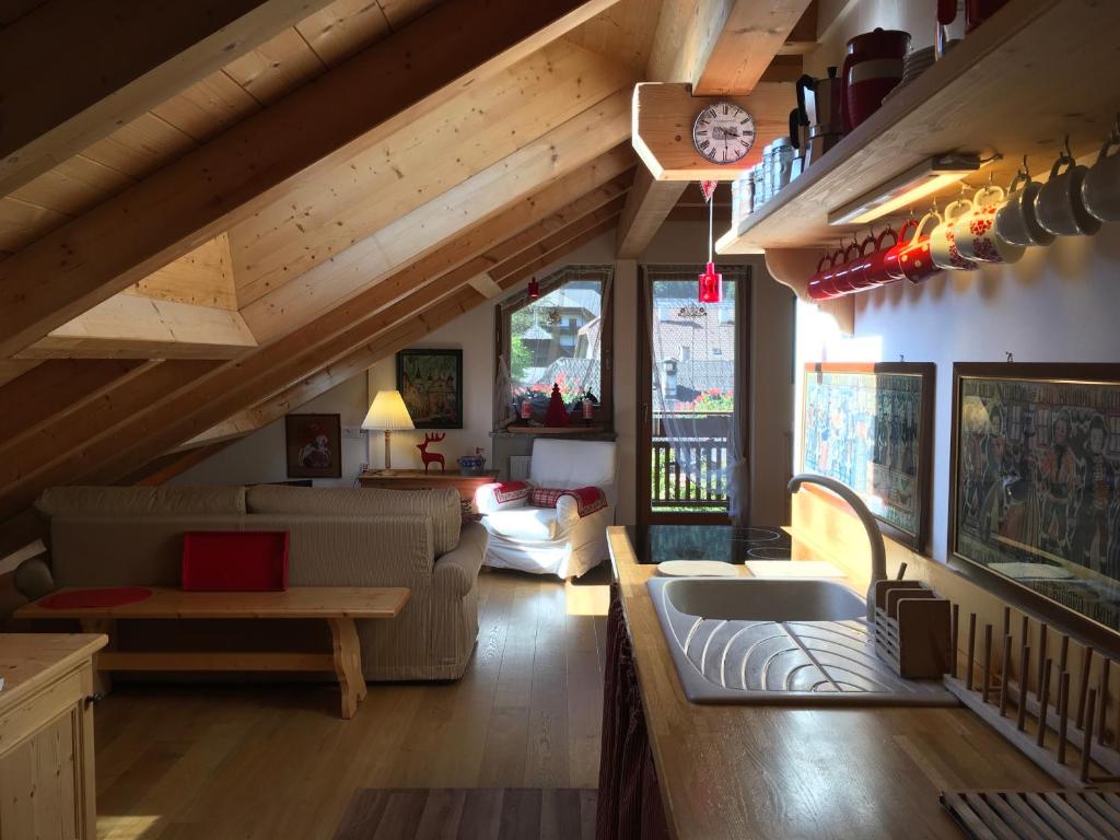 ein Wohnzimmer mit einem Sofa und einem Tisch in der Unterkunft Mansarda Dolomiti in Oberrasen