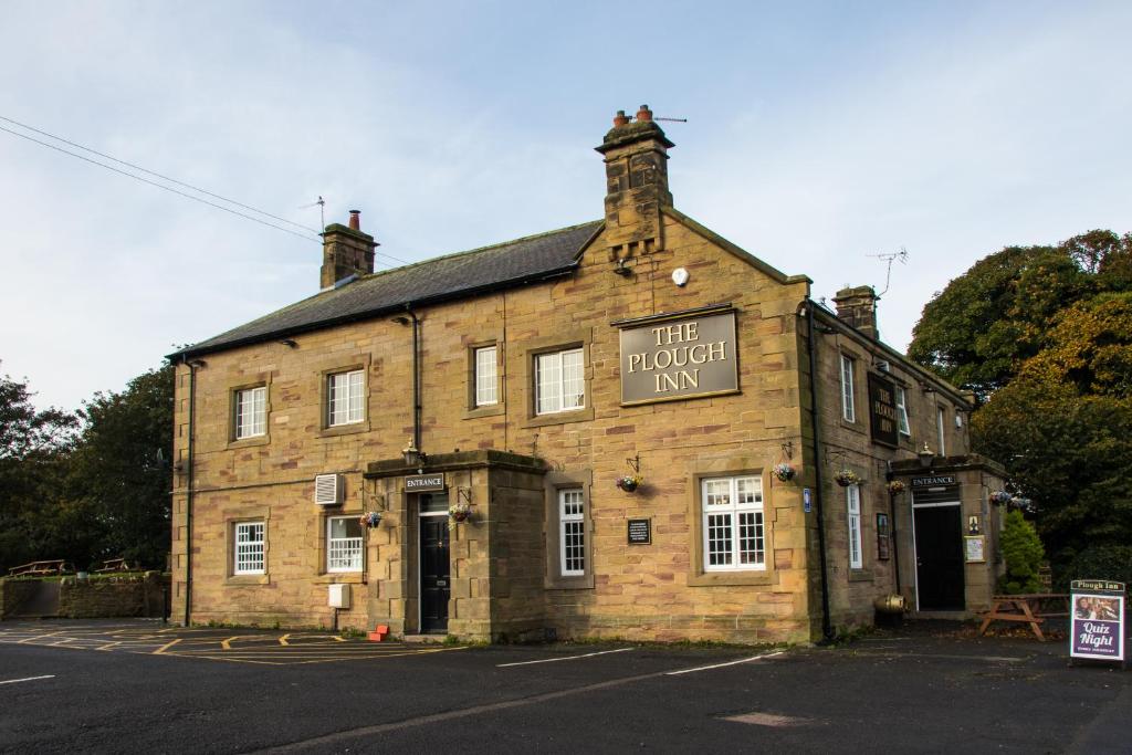 een oud bakstenen gebouw met een bord dat de verboden herberg leest bij Plough Inn in Morpeth