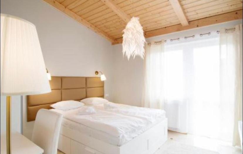 a bedroom with a white bed and a window at Apartament Platinum 1 in Ustroń