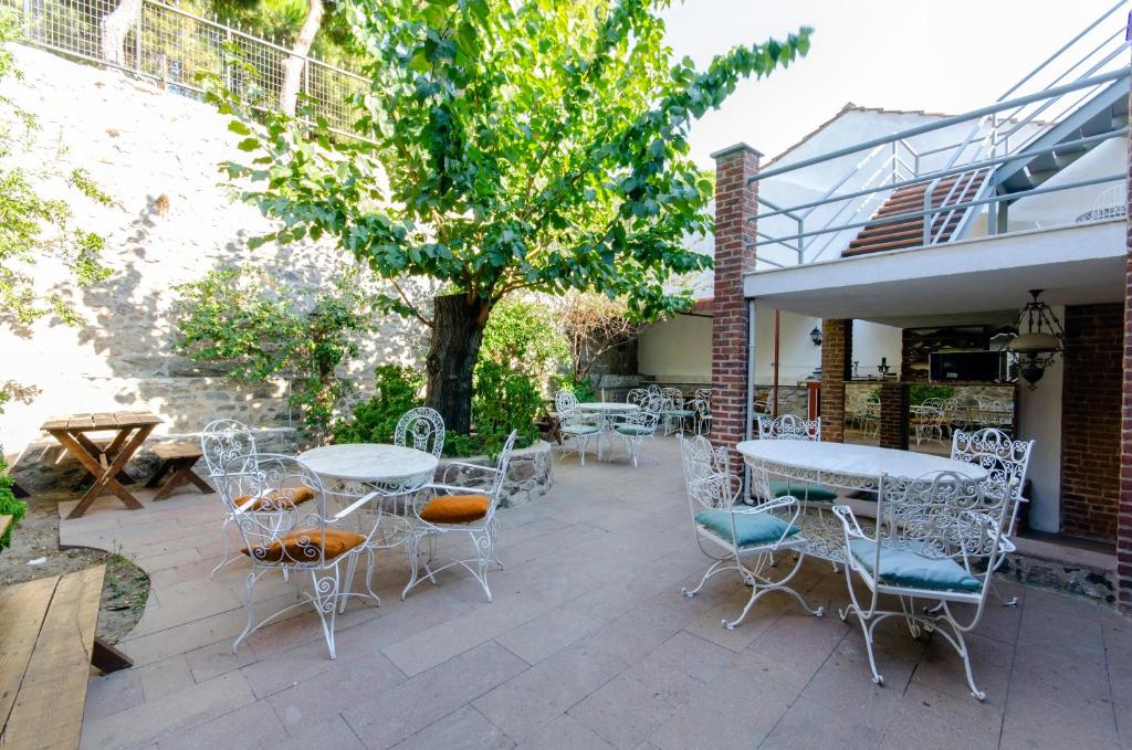 un patio con mesas, sillas y un árbol en Dutlu Konak, en Izmir