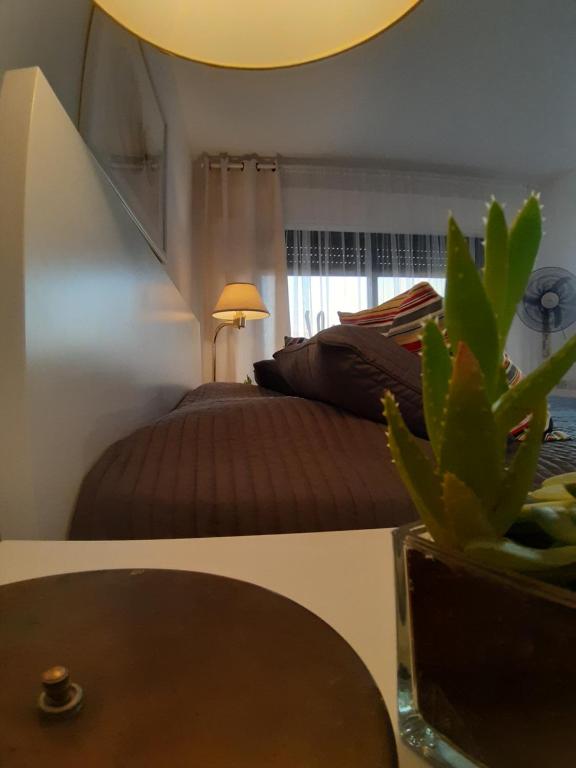Un dormitorio con una cama y una mesa con una planta en The Place en Madaba