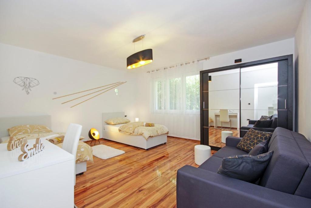 ein Wohnzimmer mit einem Sofa und einem Bett in der Unterkunft Split Symphony Veranda: Modern, new Apartment (4+1), 5 min walk to ˝Firule˝ SAND BEACH, 12 min walk to CITY CENTER in Split