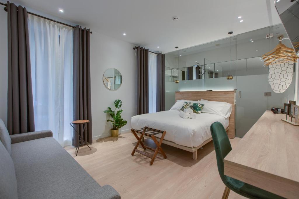 um quarto com uma cama, um sofá e um espelho em The Match Madrid em Madrid